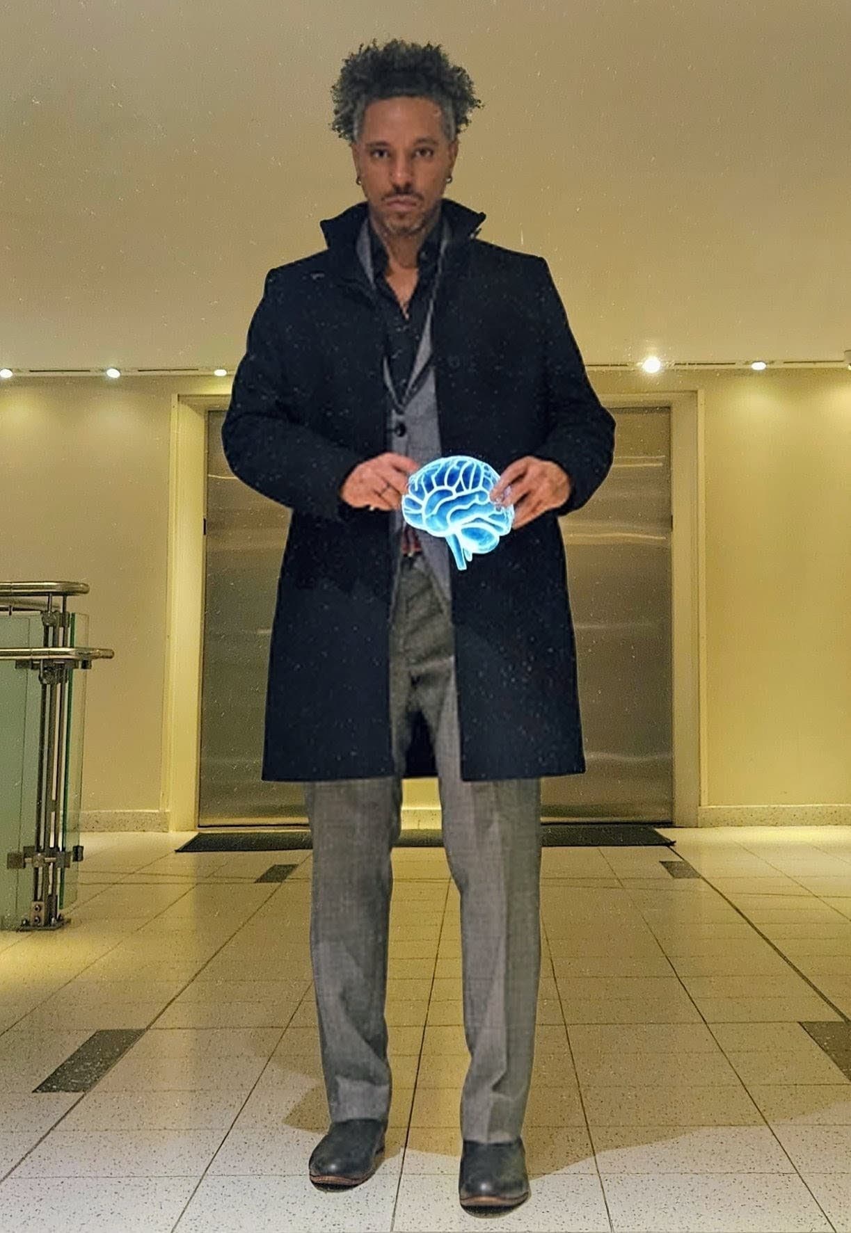 Man in a dark overcoat and grey suit holding a glowing blue holographic brain.